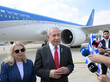 Der israelische Ministerpräsident Benjamin Netanjahu steht mit seiner Frau vor einem Flugzeug und gibt der Presse ein Interview.