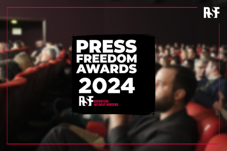 Der Schriftzug Press Freedom Awards 2024 vor dem Hintergrund eines vollbesetzten Kinosaals.