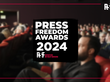 Der Schriftzug Press Freedom Awards 2024 vor dem Hintergrund eines vollbesetzten Kinosaals.